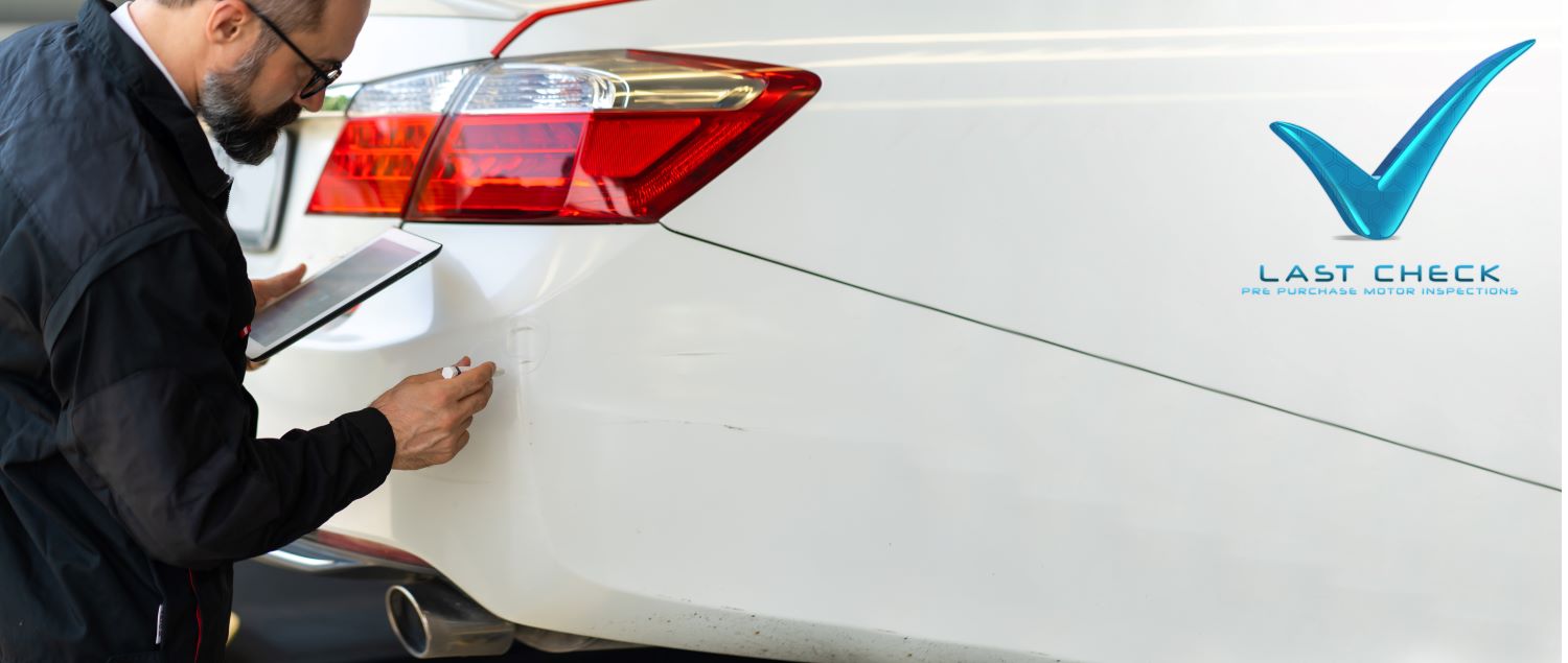 Vehicle Inspector Inspecting A White Car