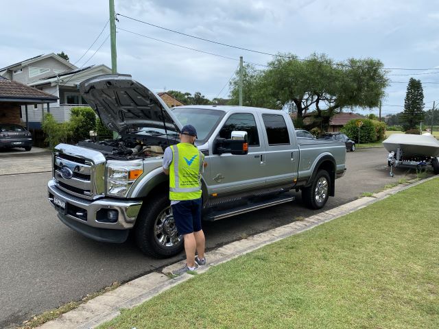 last-check-qualified-mechanic-inspecting-a-used-ford-truck